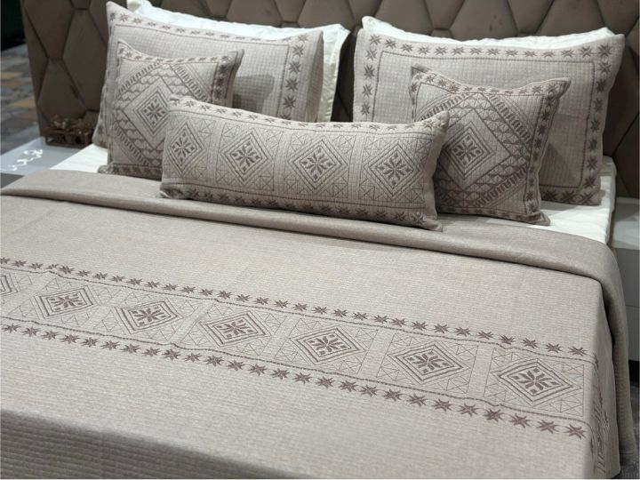 Bed with patterned bedding and pillows in a bedroom setting