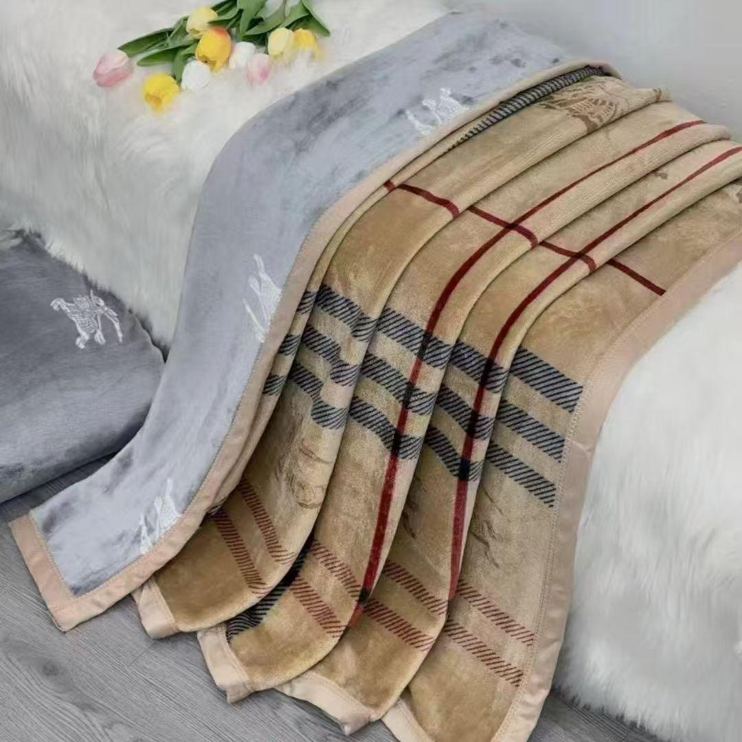 Beige checkered blanket on a bed with gray pillow and tulips.
