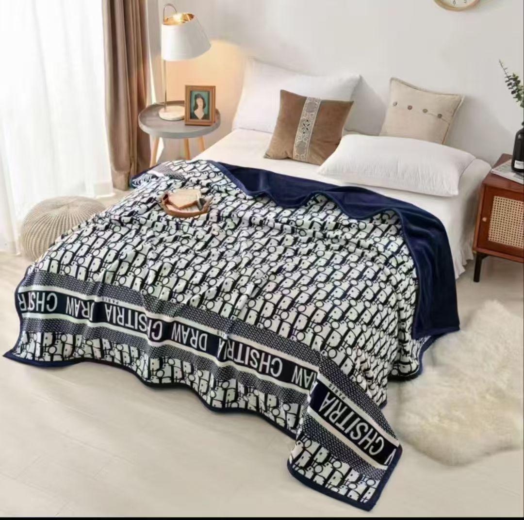 Bed with a patterned blanket draped over it in a bedroom setting.