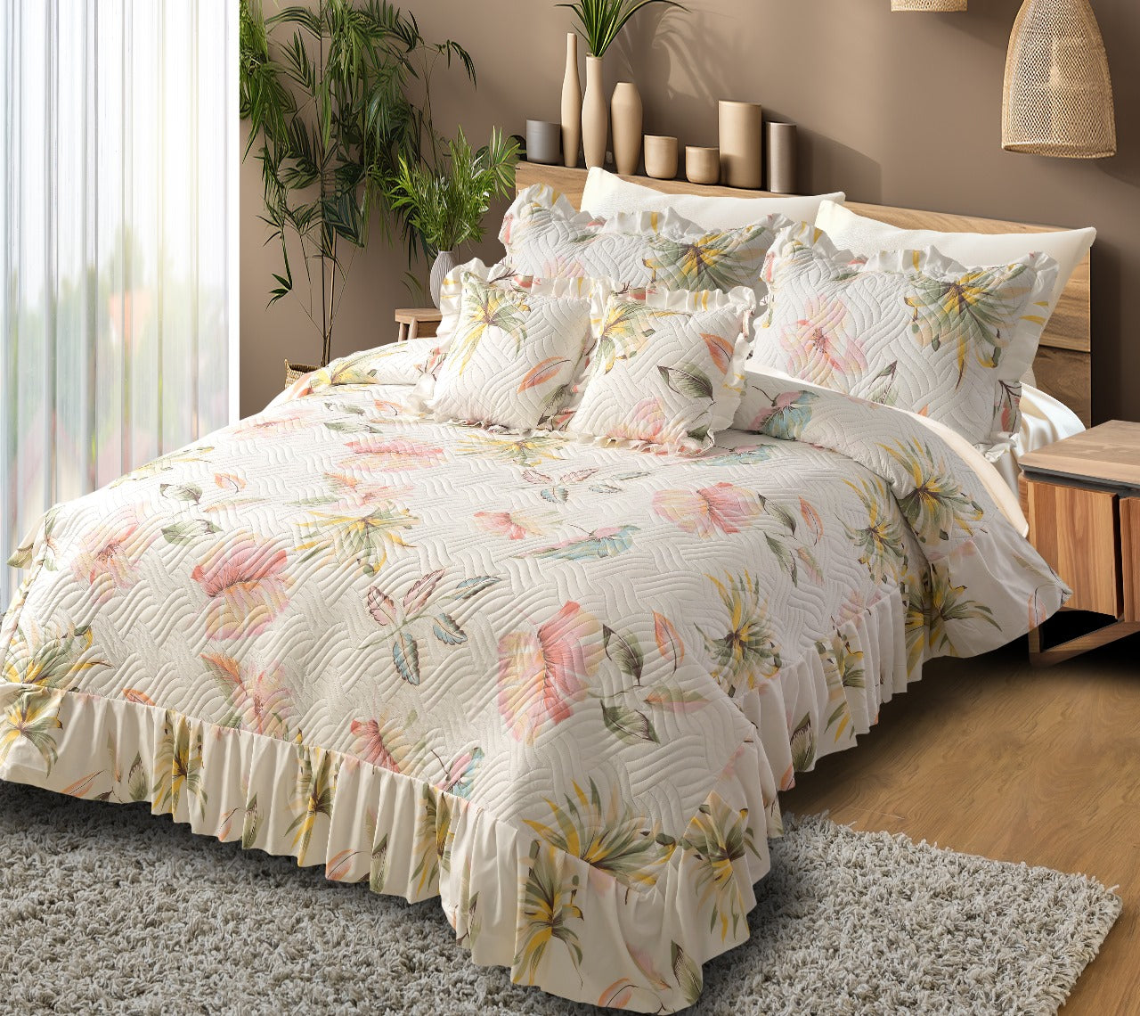 Floral quilt set on a bed in a bedroom with plants and decor.