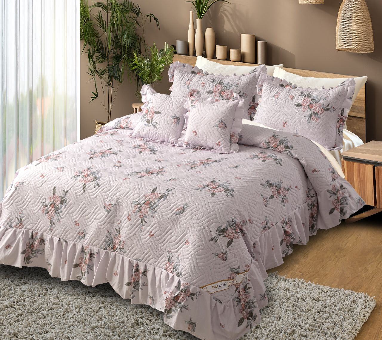 Floral bedding set on a bed in a bedroom with plants and decor.