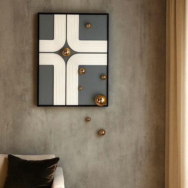 Geometric wall art with gold accents on a concrete wall