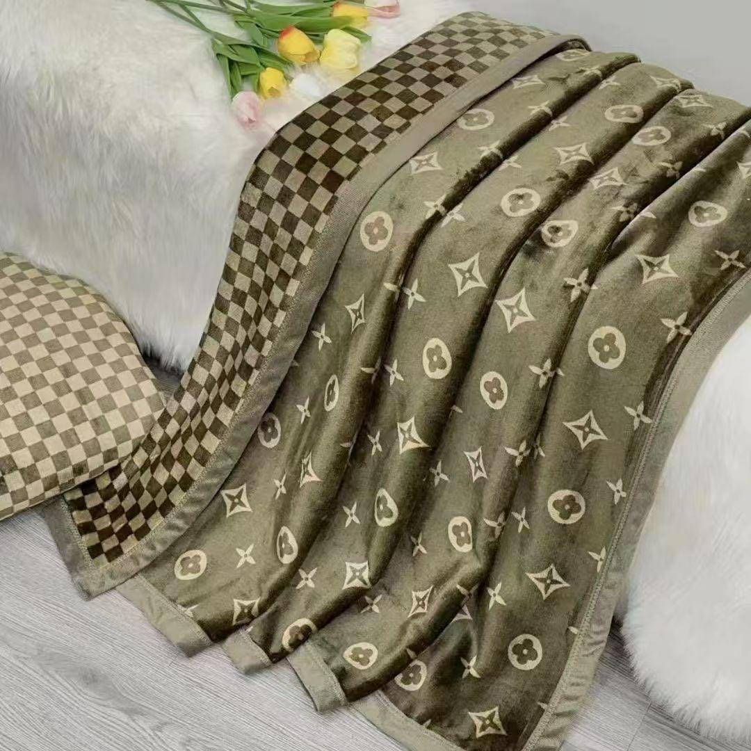 Green patterned blanket on a white surface with flowers in the background