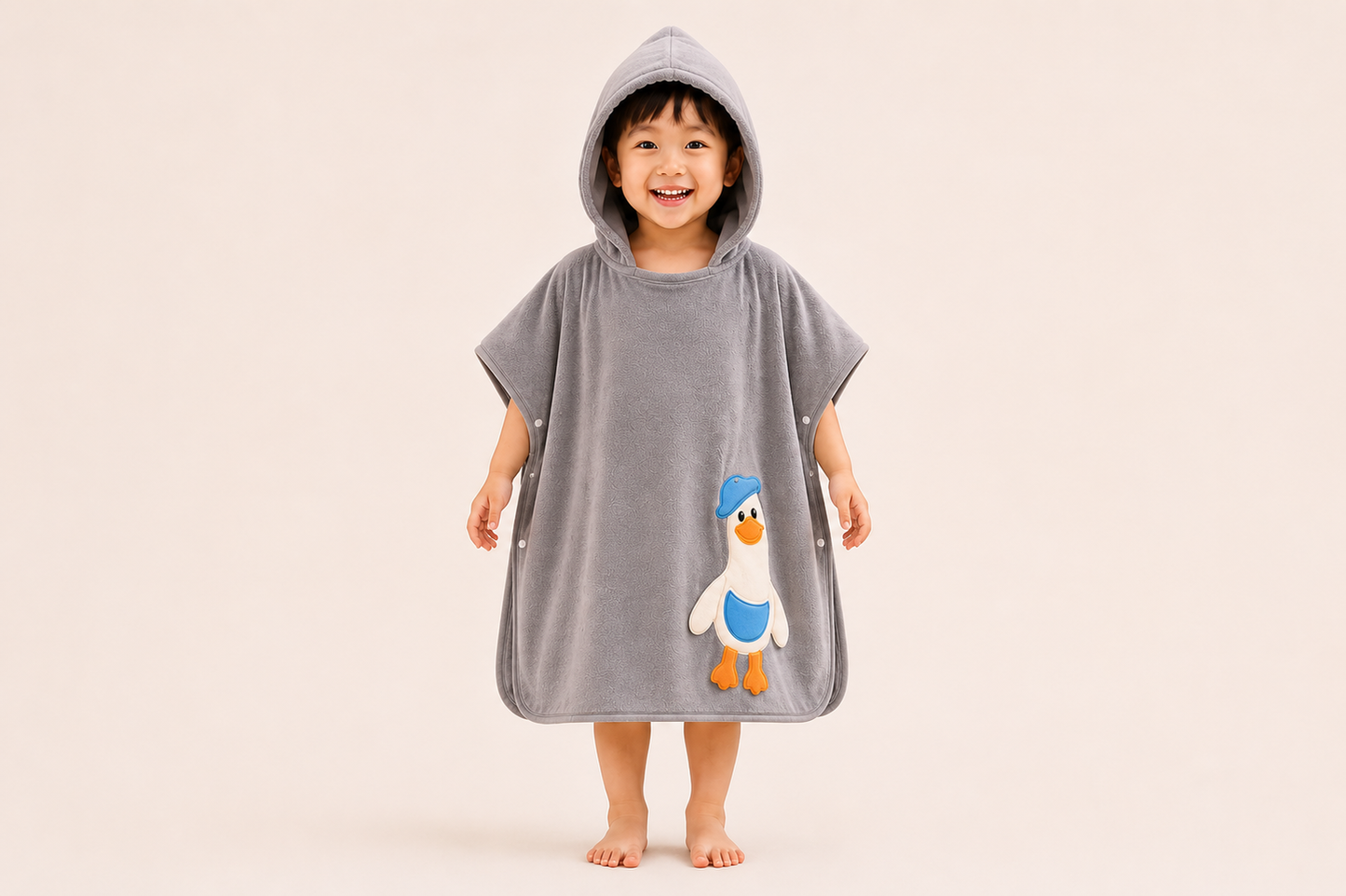 Grey hooded bath poncho towel for kids by The Gharnish, featuring a soft, absorbent hooded towel for children’s bath time.