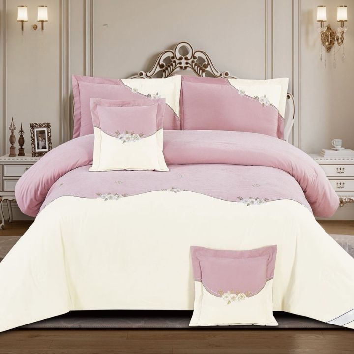 Pink and white bedding set on a bed in a bedroom setting.
