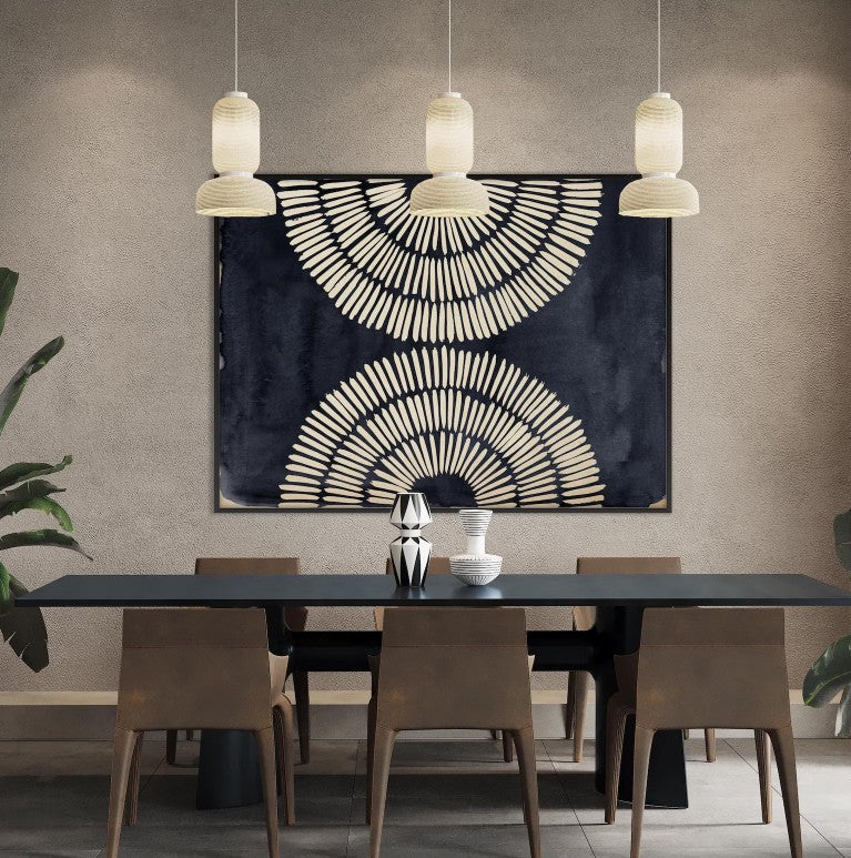 Dining room with a black table and chairs, abstract wall art, and pendant lights.