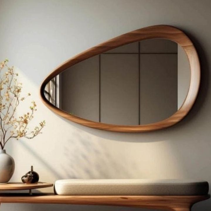 Wooden mirror with a unique design on a wall above a console table.