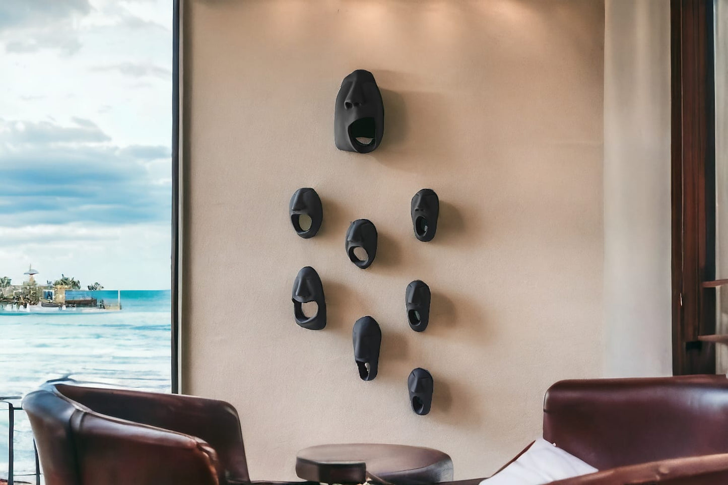 Wall with decorative black sculptures near a window with a view of water and sky.