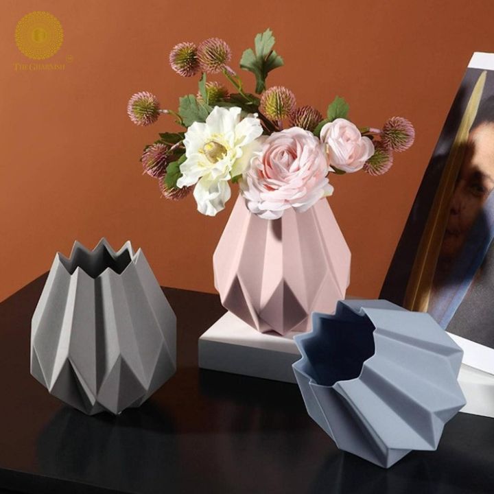 Small black ceramic vase shaped like a lotus flower by The Gharnish, featuring intricate petal details and a glossy finish.