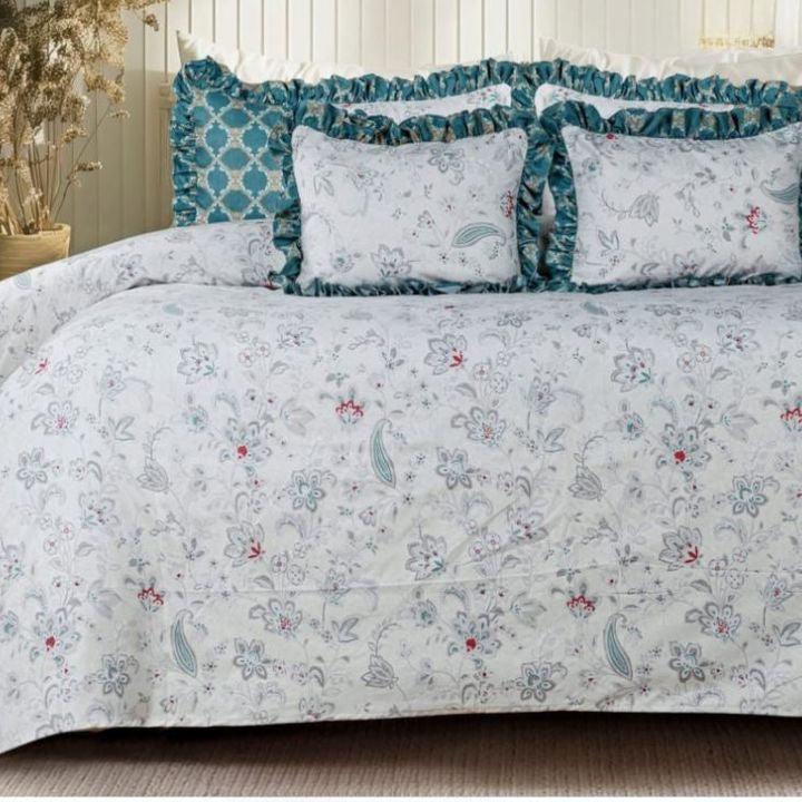 Serenity Bloom quilted bedding set by The Gharnish with five pieces, featuring floral and geometric patterns in soft pastel colors.