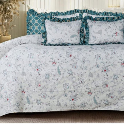 Serenity Bloom quilted bedding set by The Gharnish with five pieces, featuring floral and geometric patterns in soft pastel colors.