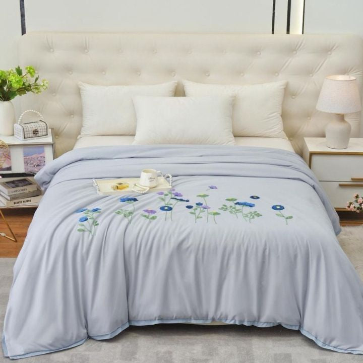 The Gharnish Florista Double Bed Embroidery Comforter with floral embroidery in soft pastel colors on white fabric.