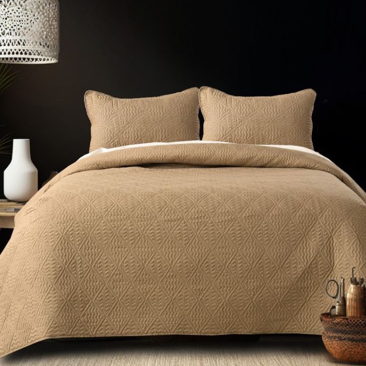 Sensation Quilted designer bedding set by The Gharnish featuring luxurious quilted fabric in elegant patterns on a bed.