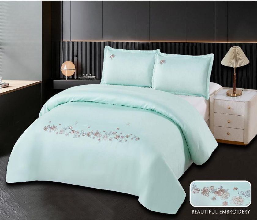 Cotton embroidery bedding set by The Gharnish featuring a detailed floral pattern on soft white bedding for a cozy bedroom look.