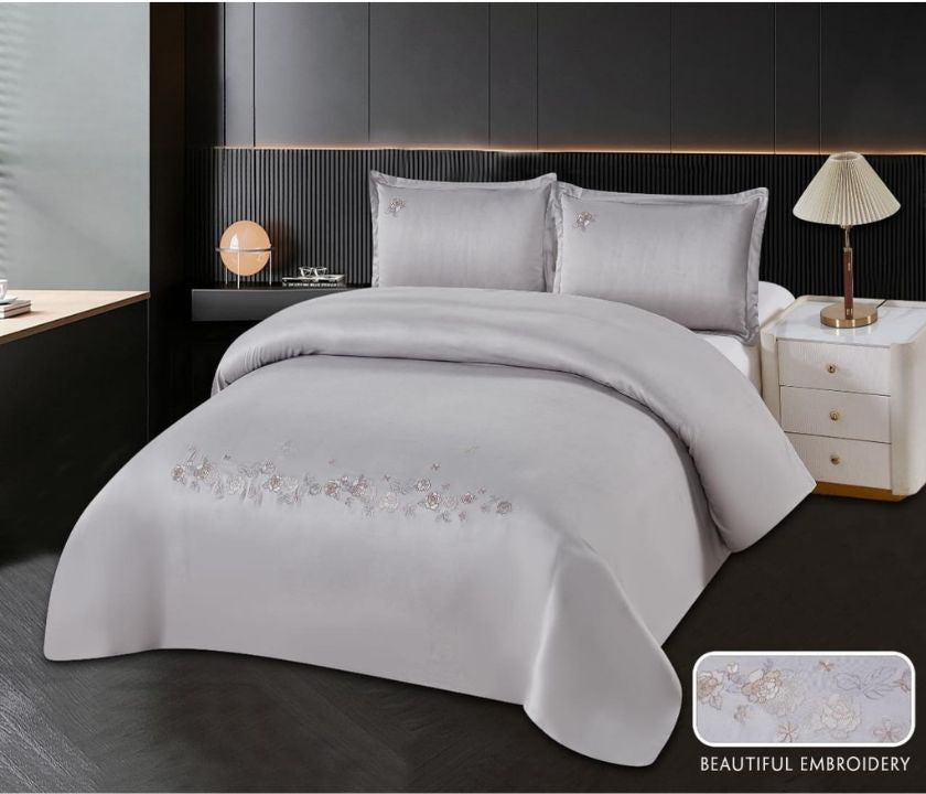 The Gharnish 100% cotton embroidery bedding set featuring a floral design on soft, white fabric for a cozy bedroom look.