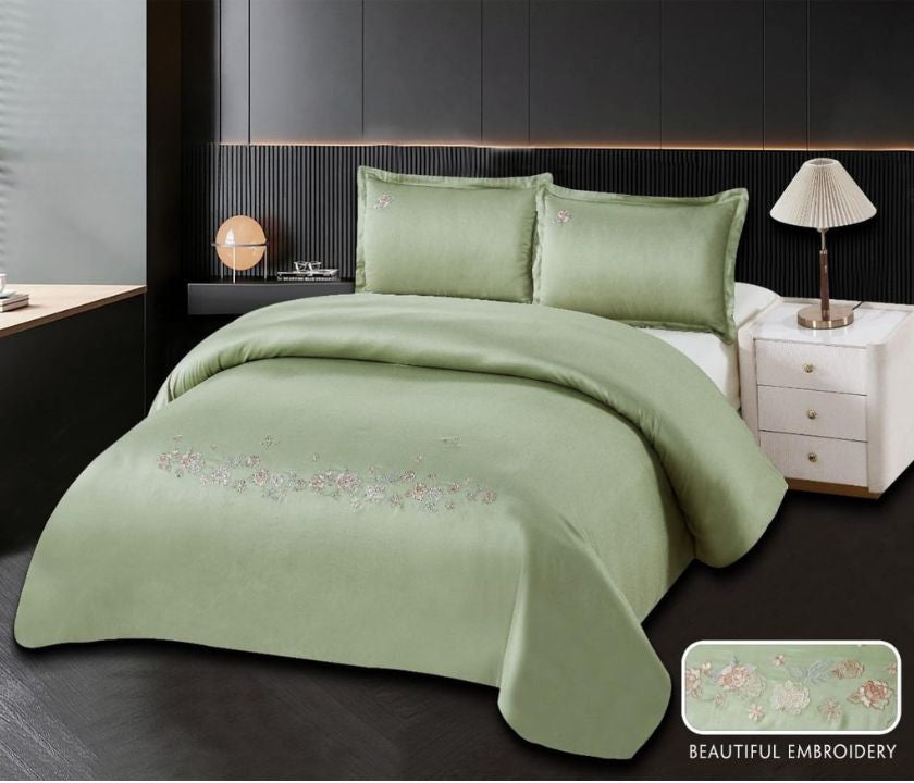 The Gharnish 100% cotton embroidery bedding set featuring a floral pattern on a white bedspread with matching pillowcases.