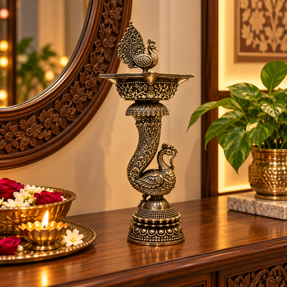 Pair of brass peacock-shaped diyas with traditional handcrafted design for decorative oil lamps on wooden console.
