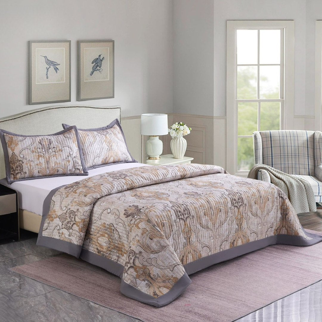 Bedroom with floral-patterned comforter, pillows, and a lamp.