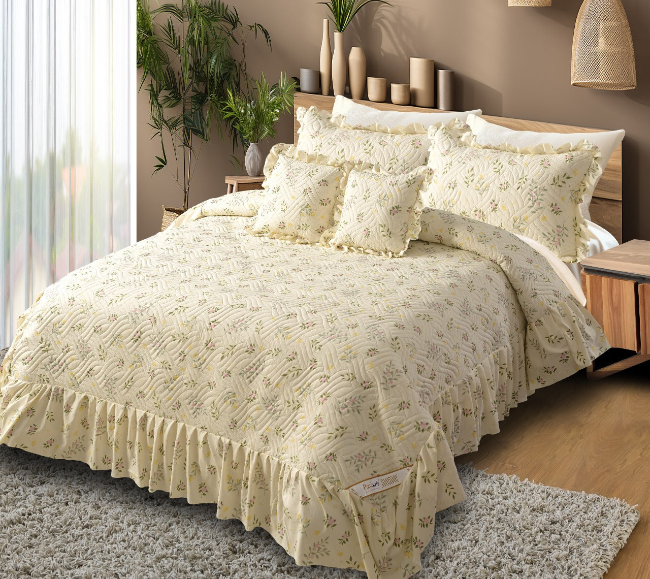 Beige floral patterned bedding set on a bed in a bedroom with plants and decor.
