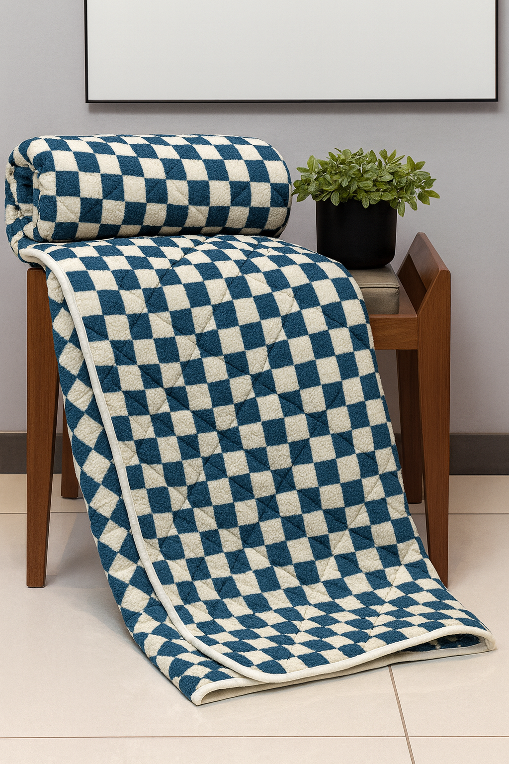 Blue and white checkered blanket draped over a wooden chair with a plant in the background.