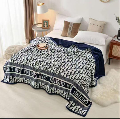 Bed with a patterned blanket draped over it in a bedroom setting.