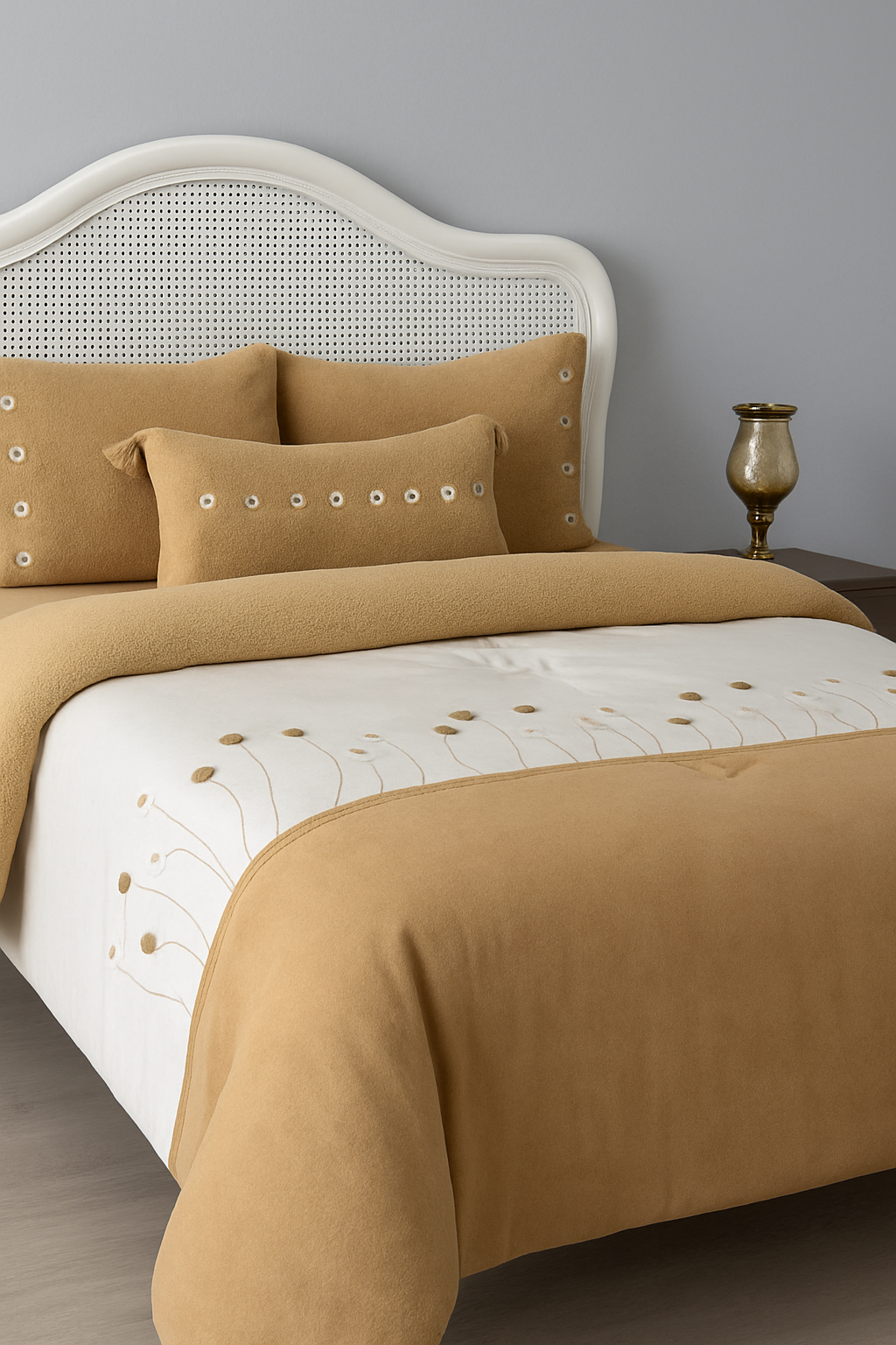 Brown bedding set with decorative patterns on a bed against a gray wall.