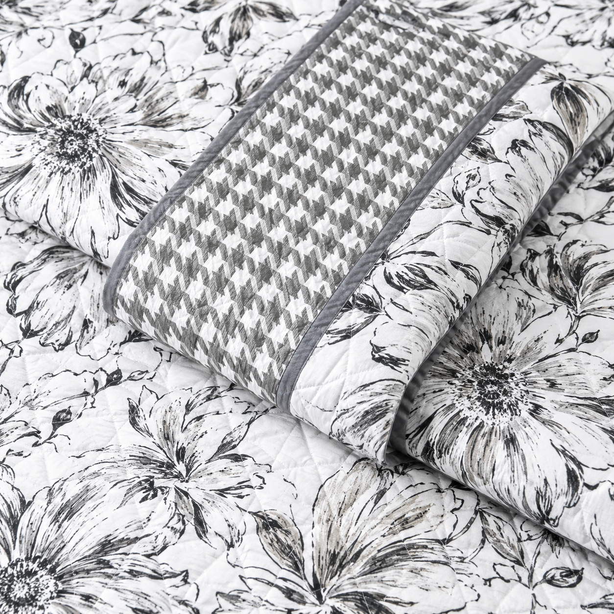 Floral bedding set of 3 with soft quilted bedcover and two matching pillow covers by The Gharnish on a bed.