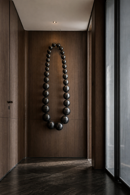 Obsidian bead wall sculpture by The Gharnish, modern wall art featuring glossy black beads arranged in an abstract design.