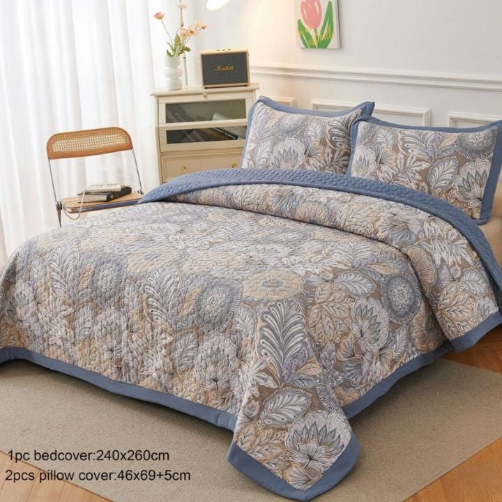 Floral patterned bedspread set on a bed in a bedroom setting.