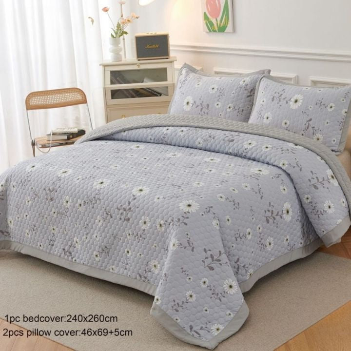 Floral patterned bedspread set on a bed in a bedroom setting.