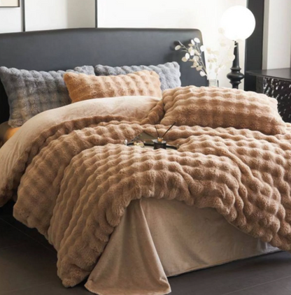Fluffy beige comforter on a bed with pillows in a bedroom setting