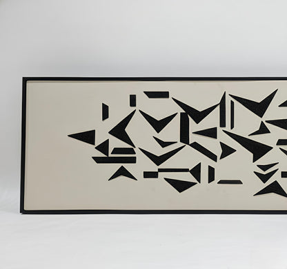 Framed abstract art with black geometric shapes on a beige background