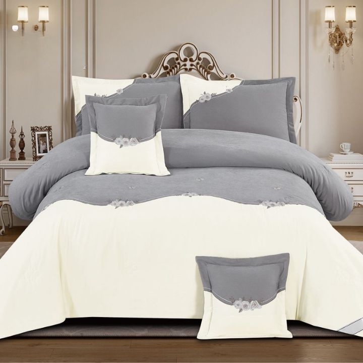 Gray and white bedding set on a bed in a bedroom setting.