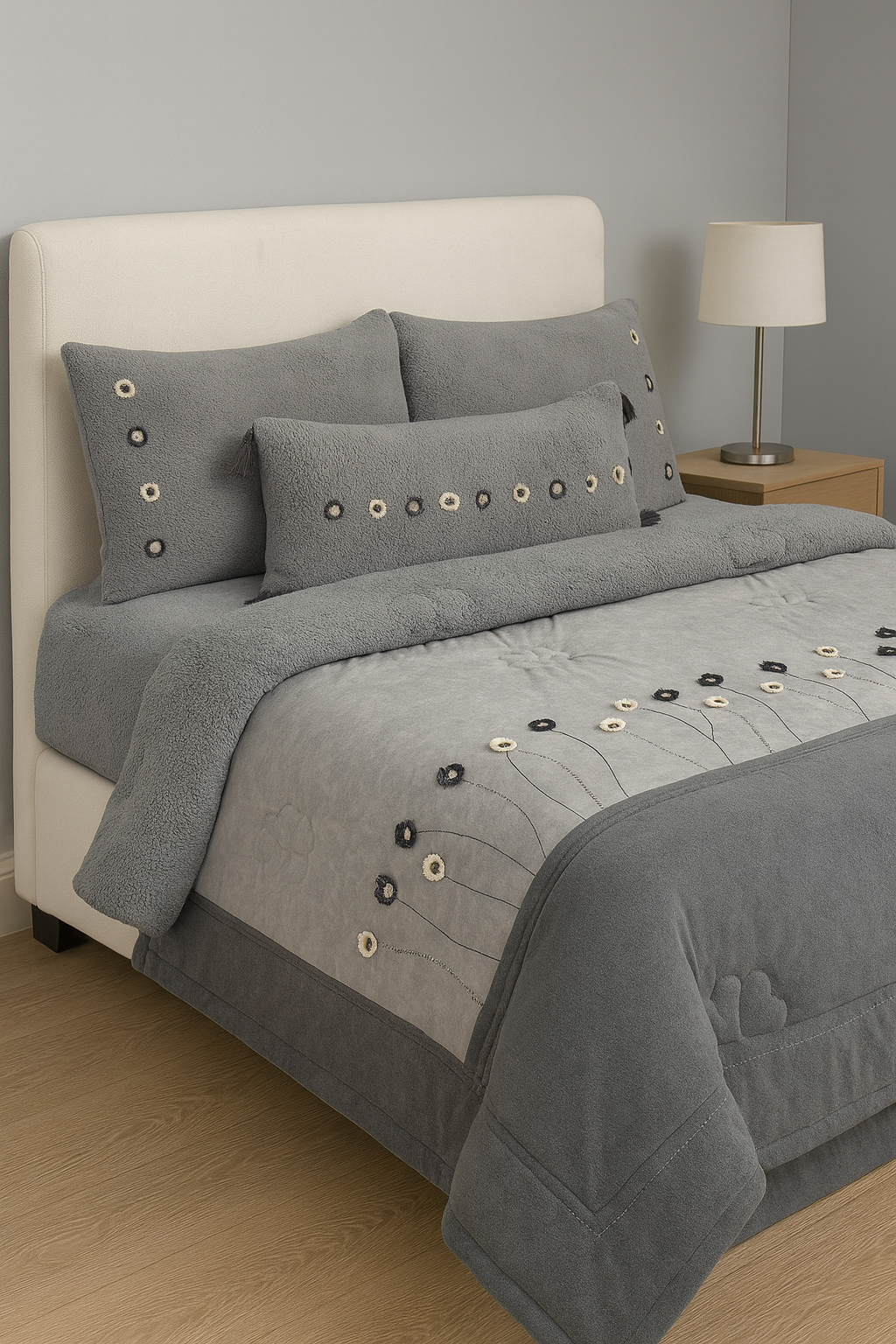 Gray textured comforter set on a bed with decorative pillows in a bedroom setting.