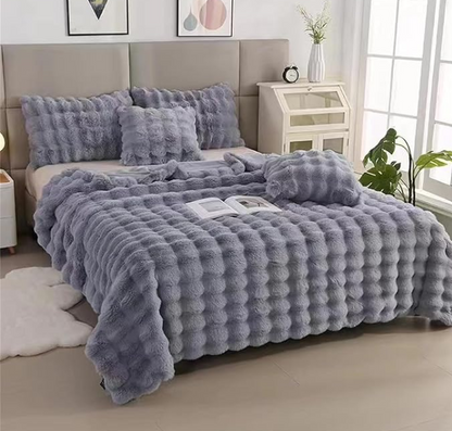 Gray textured comforter set on a bed in a bedroom setting