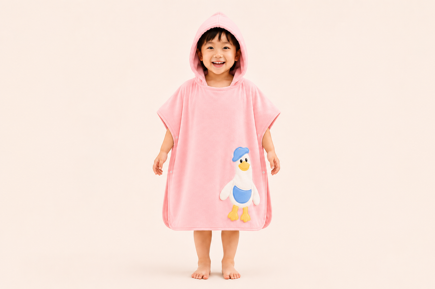 Pink hooded bath poncho towel for kids by The Gharnish featuring a fun duckieHug design, soft and cozy for drying after bath.