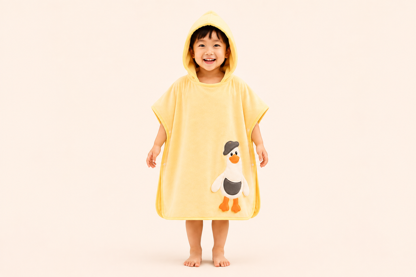 Yellow hooded bath poncho towel for kids by The Gharnish, cozy and soft, featuring a fun duckieHug design for children.