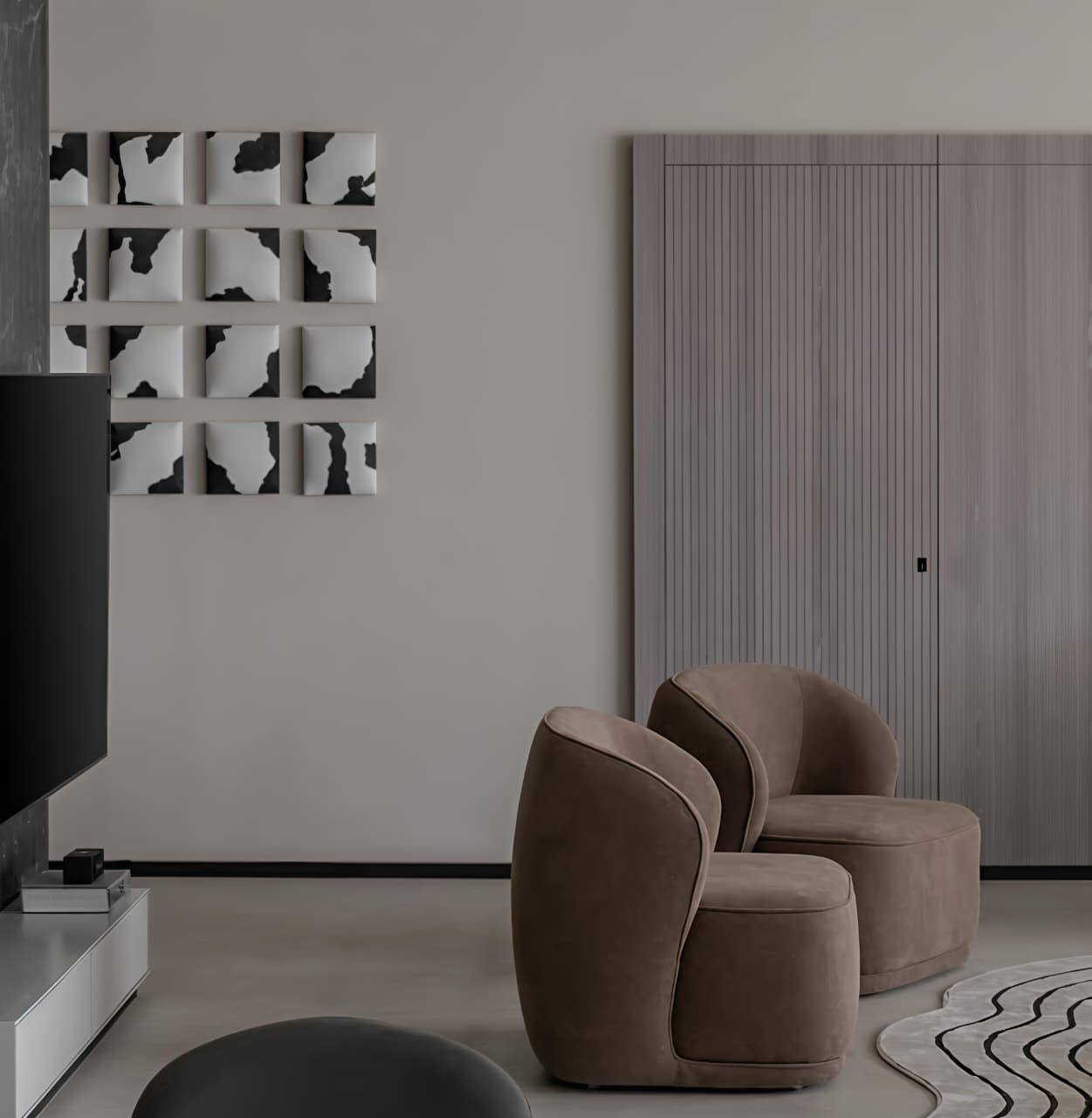 Modern living room with brown armchairs, a TV, and abstract wall art.