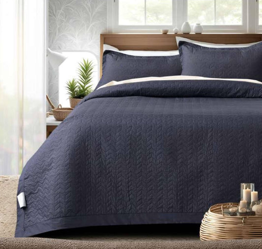 Navy blue quilted bedcover from The Gharnish Serene Stitch Premium Bedding set, showcasing a soft, textured quilted design.
