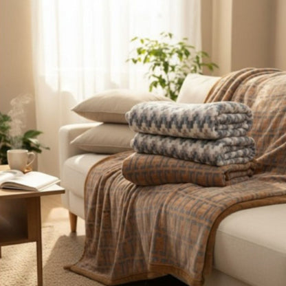 Stack of patterned blankets on a sofa in a cozy living room.