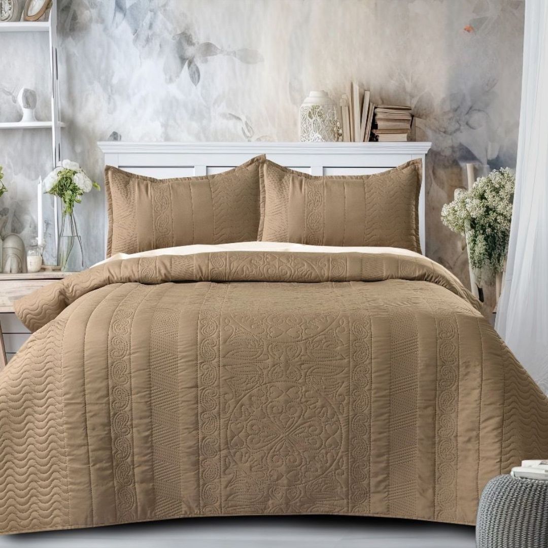 Brown quilted comforter set on a bed in a bedroom setting with decorative elements.