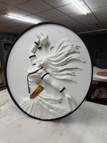 Round white sculpture of a person with long hair on a black base, in an indoor setting.