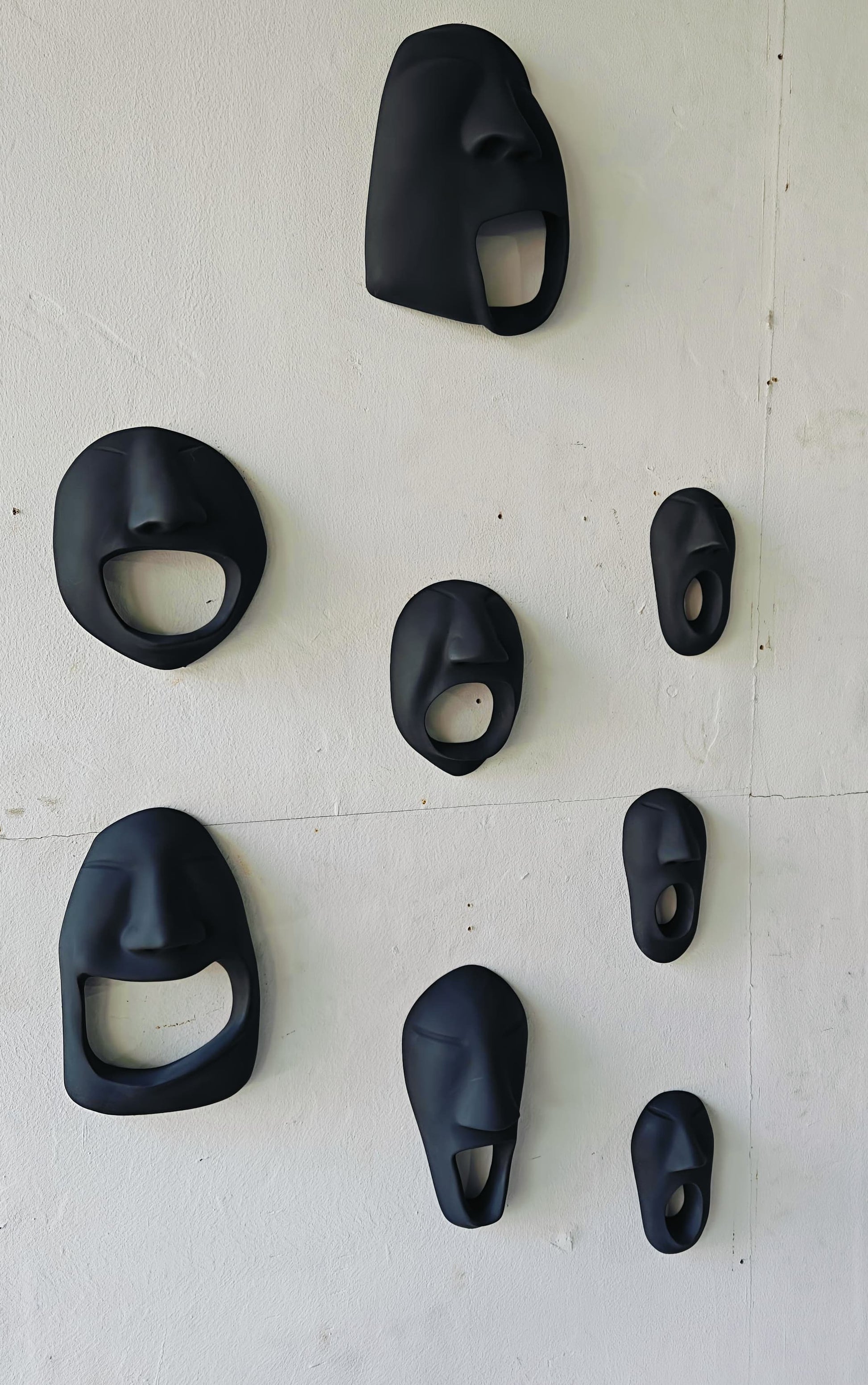 Set of black bottle openers on a white wall