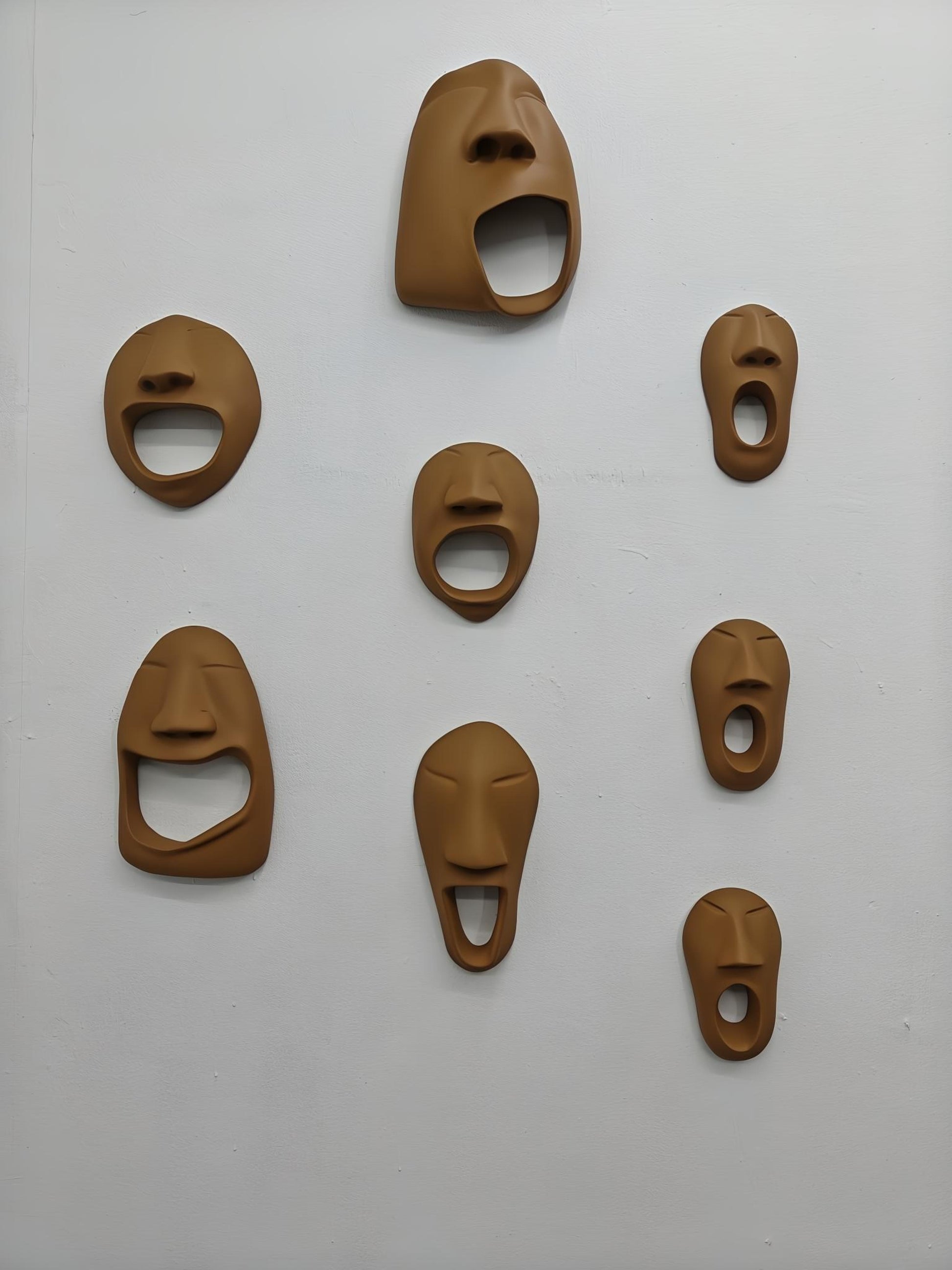 Set of brown bottle openers shaped like faces on a white background