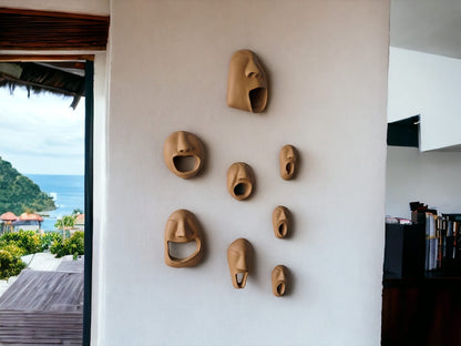 Set of ceramic face masks on a wall with a scenic view outside