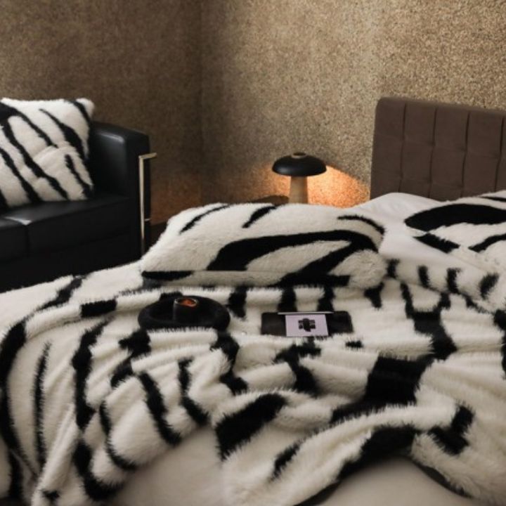 Zebra Print Faux Fur Blanket Set. Crafted with ultra-soft, high-density faux fur, this blanket brings a bold and exotic flair to your space with its striking black and white zebra pattern.