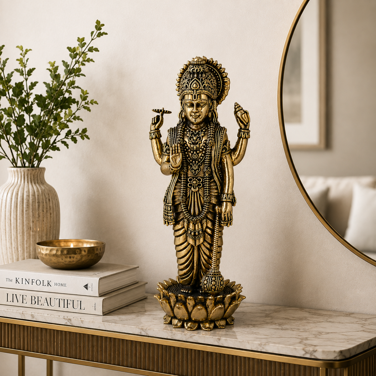 A detailed brass Lord Hanuman statue standing on a lotus base, displayed on a marble console table in a styled home interior next to a vase and books.