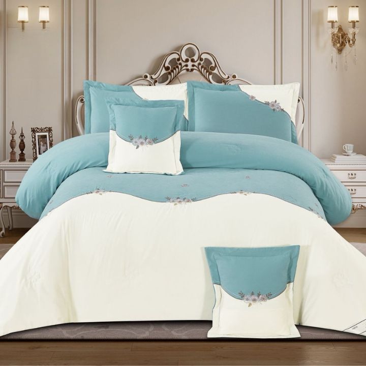 Teal and white bedding set on a bed in a bedroom setting.
