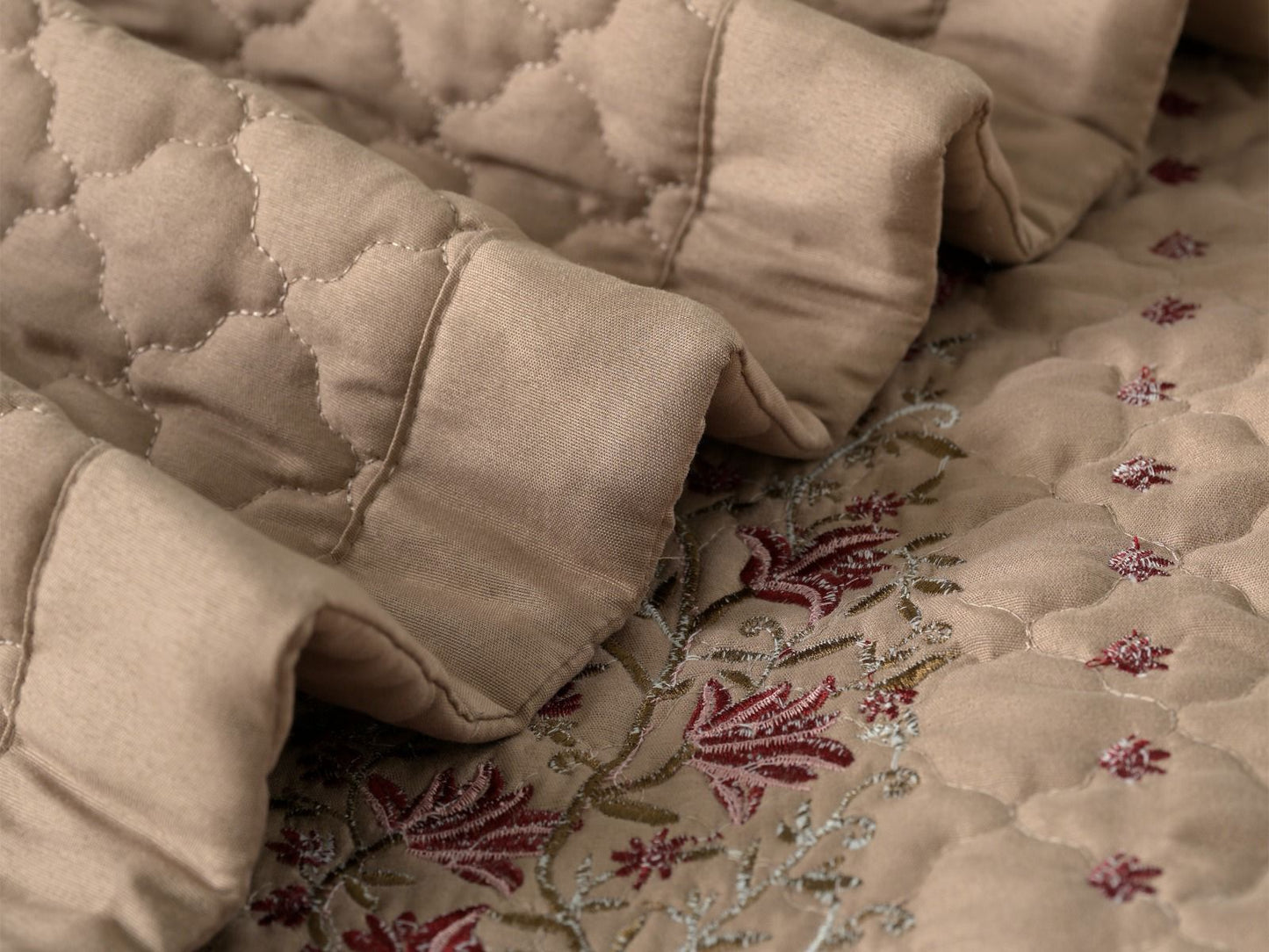 Blush Blossom quilted bedding set by The Gharnish, featuring a soft pink floral pattern on a cozy bedspread.