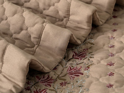 Blush Blossom quilted bedding set by The Gharnish, featuring a soft pink floral pattern on a cozy bedspread.